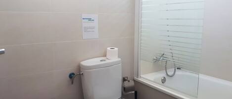 A bathroom with a toilet, sink, and a glass-enclosed shower.