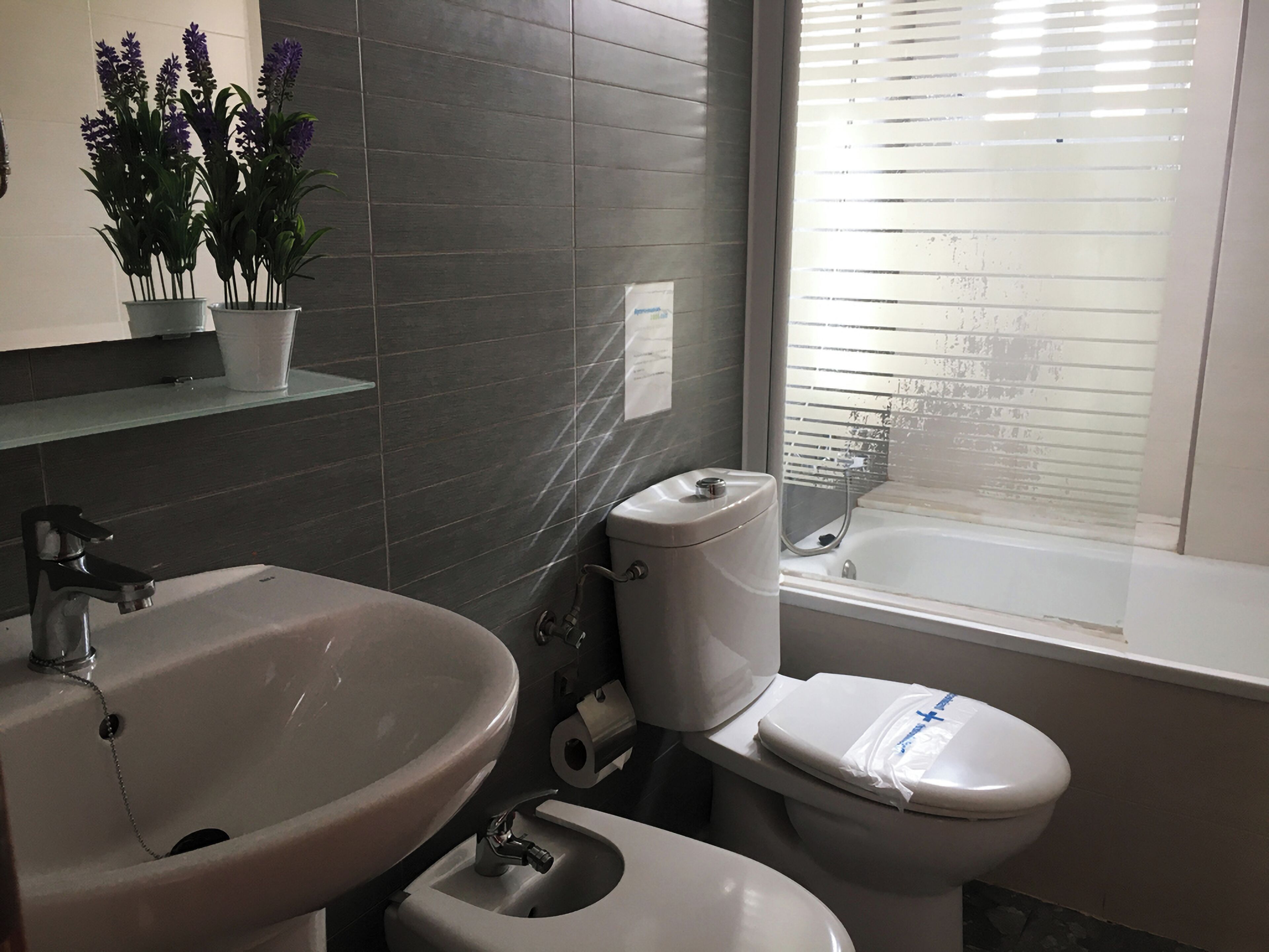 Ein Badezimmer mit Waschbecken, Toilette und Fenster.