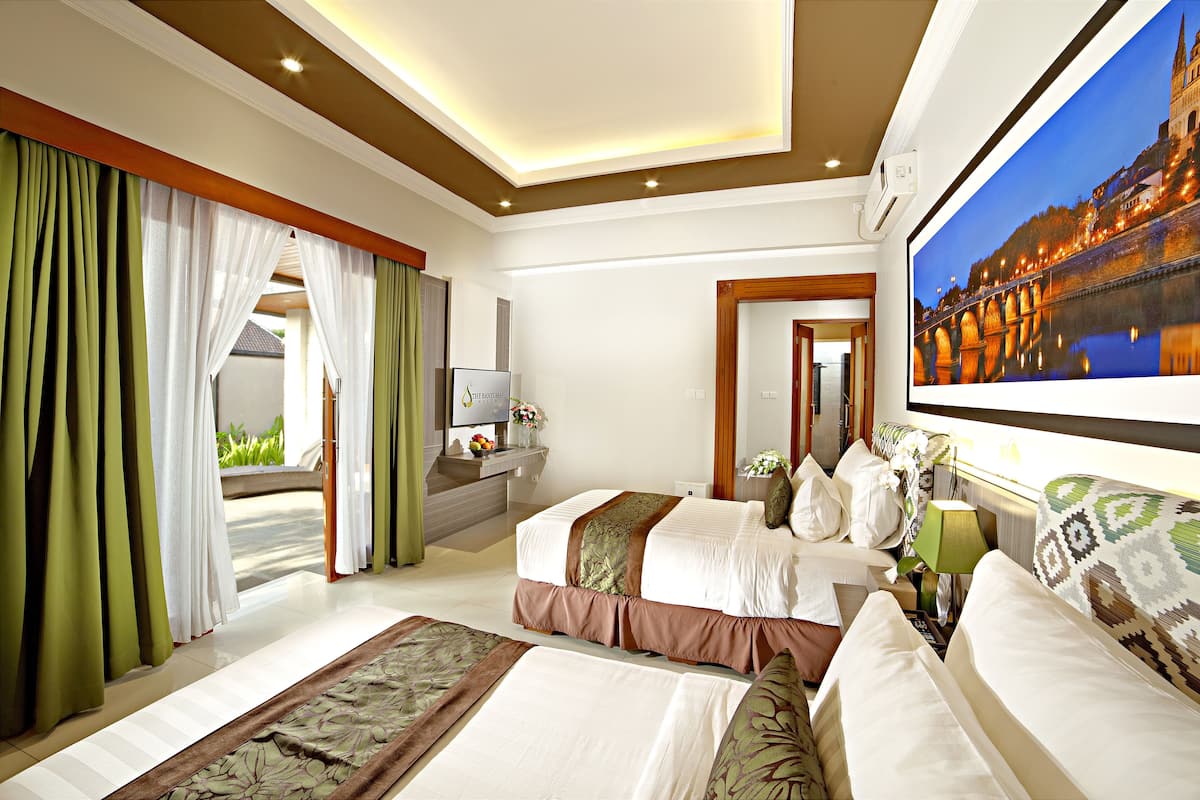 A hotel room with a large bed, a desk with a computer, and a painting of a bridge.