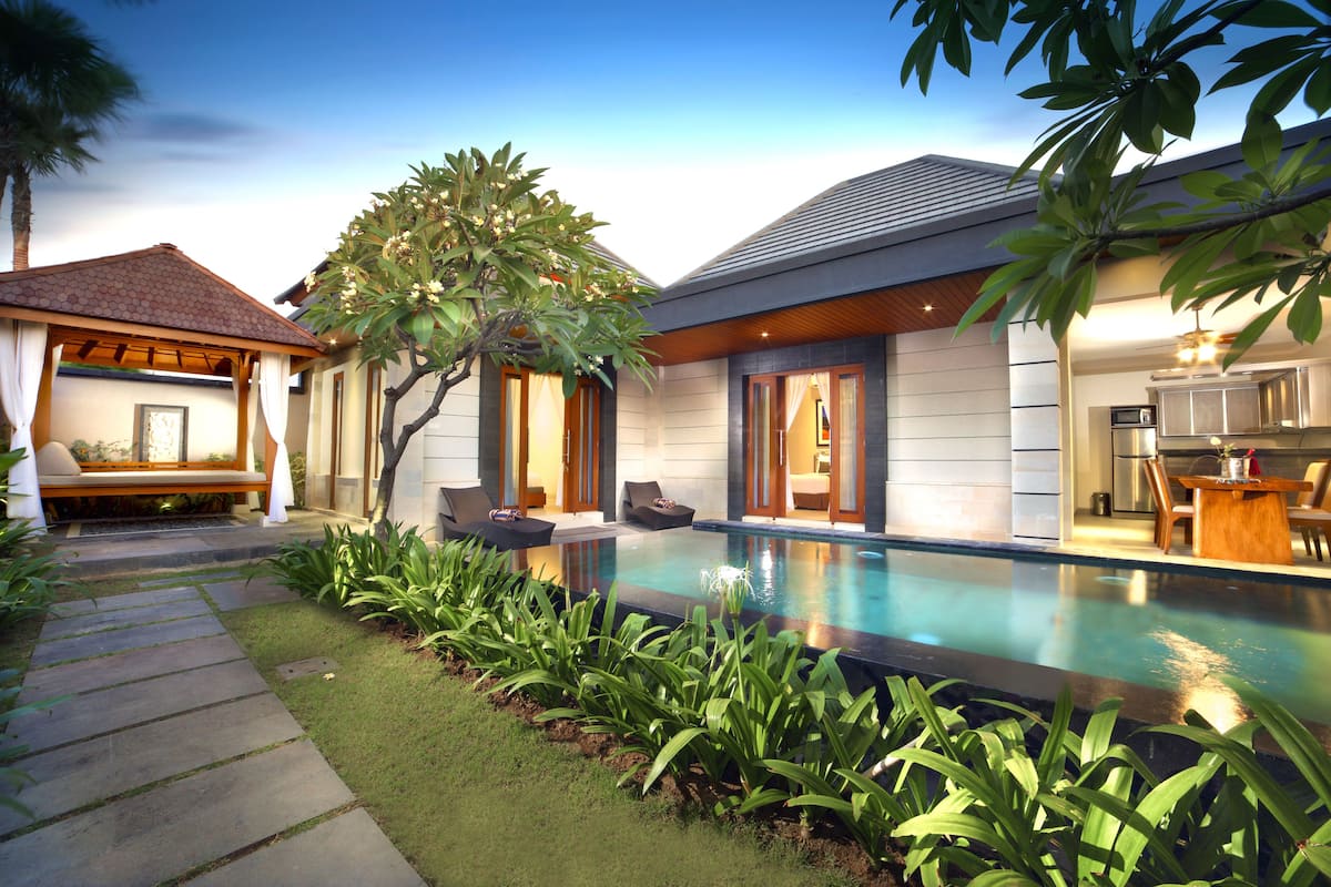 A modern house with a swimming pool, a covered patio, and a well-maintained garden.