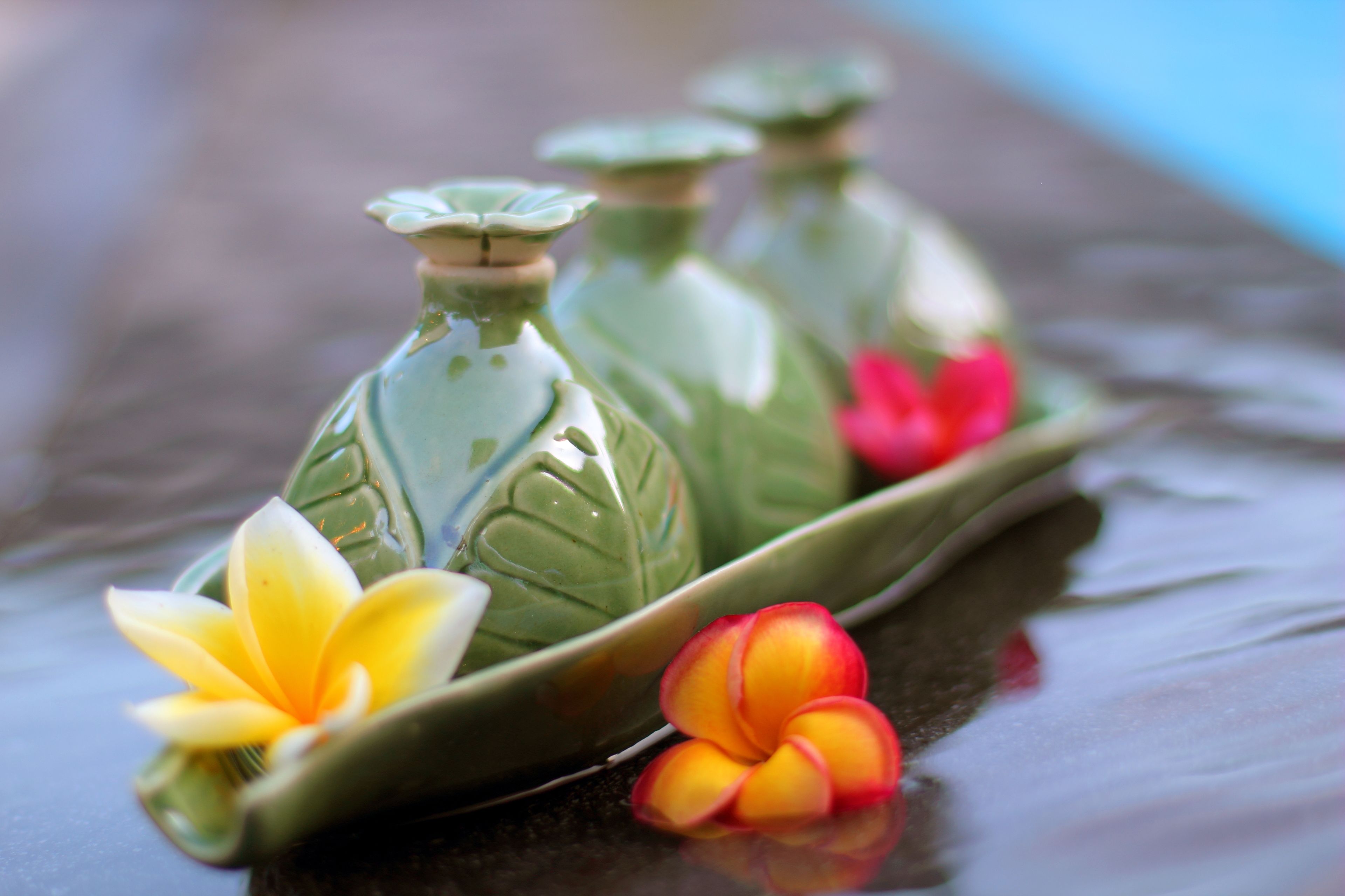 A decorative arrangement of green ceramic bottles with flowers.