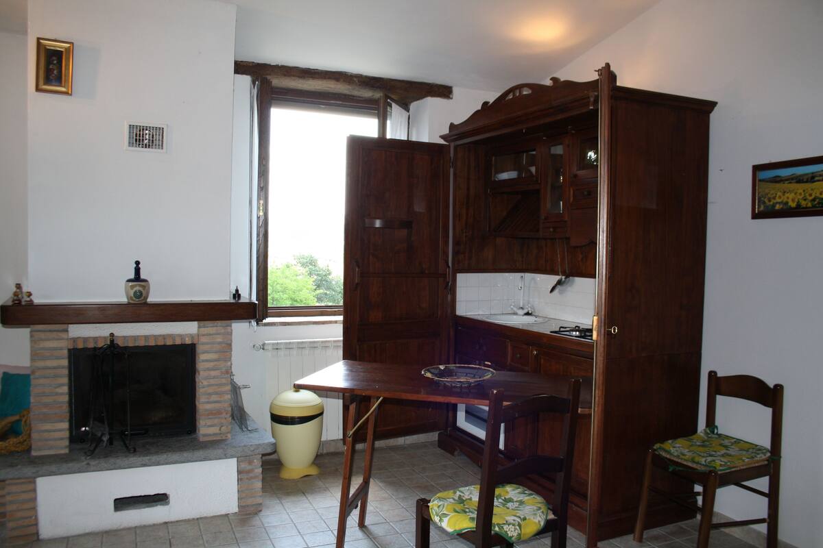 Une cuisine avec une cheminée, des armoires en bois et une table à manger.