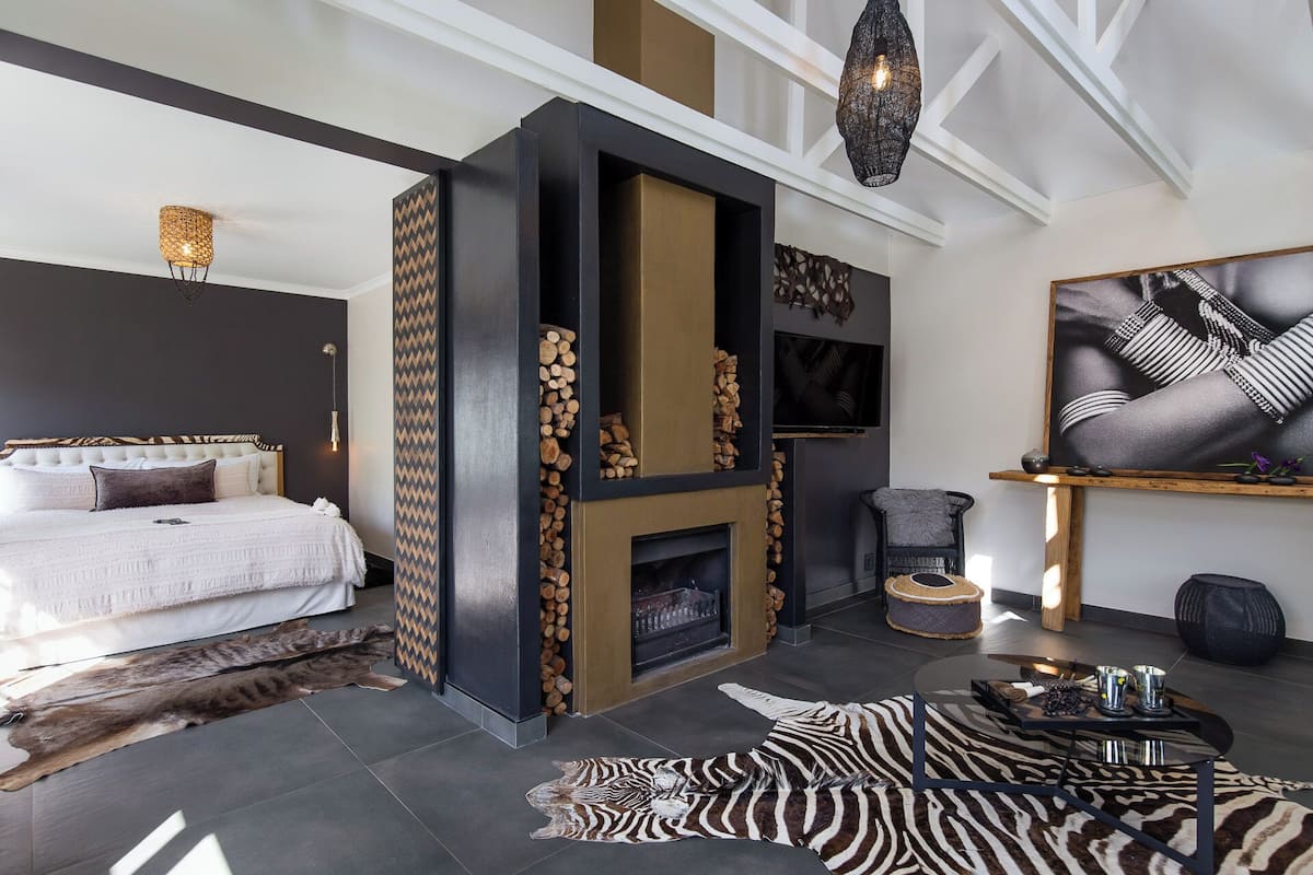 A modern living room with a fireplace, a large painting, and a zebra rug.