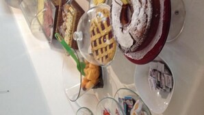 A buffet with various desserts including pies, cakes, and pastries. - Hotel Capitol (Pesaro)