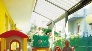 A children's play area with a slide, climbing structures, and a small house. - Hotel Capitol (Pesaro)