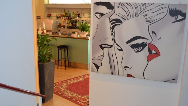 A bar area with stools, a countertop, and a potted plant. - Hotel Capitol (Pesaro)