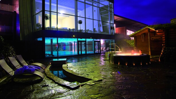 A modern building with a glass facade, a hot tub, and lounge chairs. - Enjoy Resorts Marina Fiskenæs (Grasten)