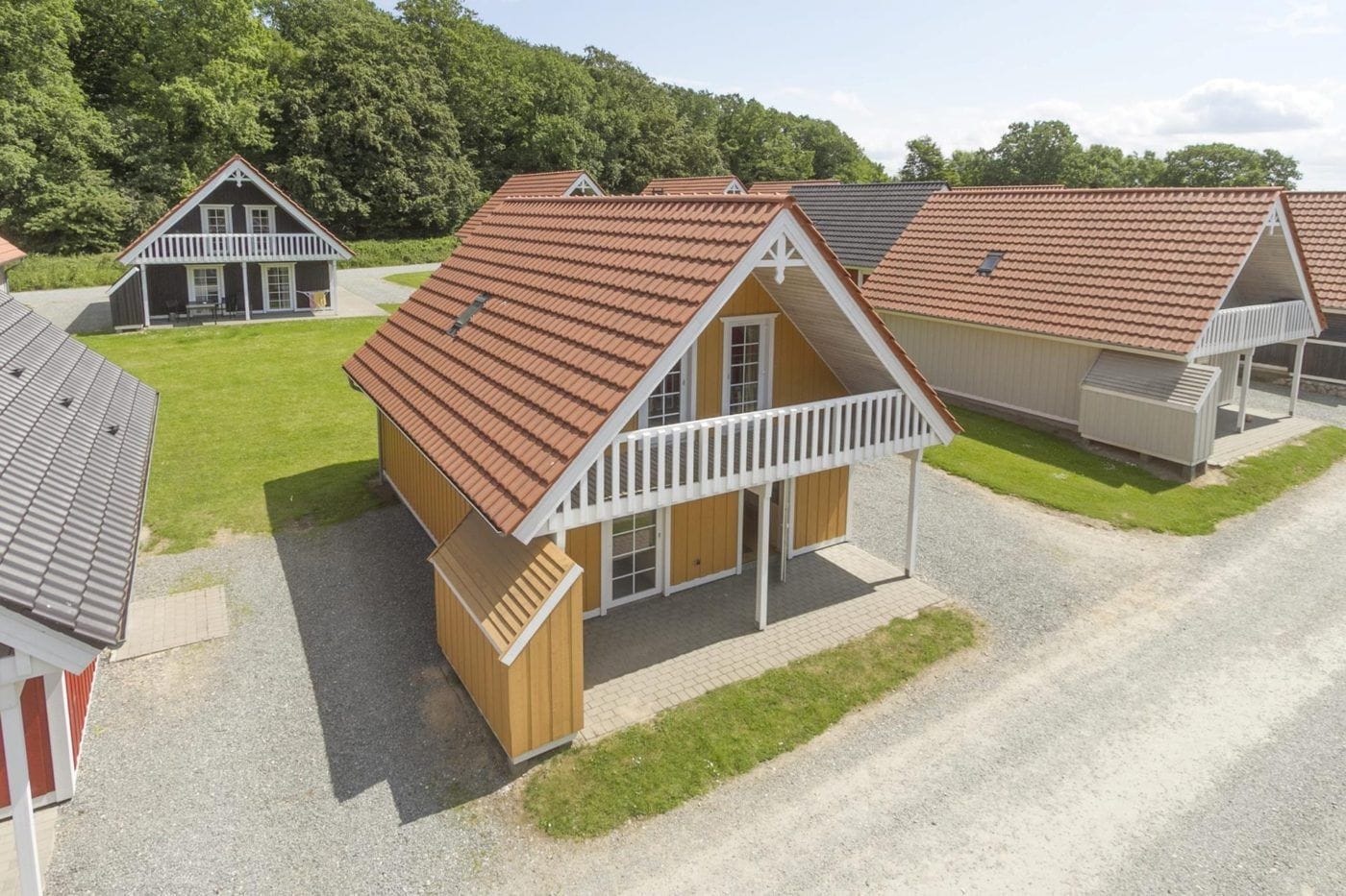 A row of single-story cabins with pitched roofs, wooden exteriors, and attached porches.