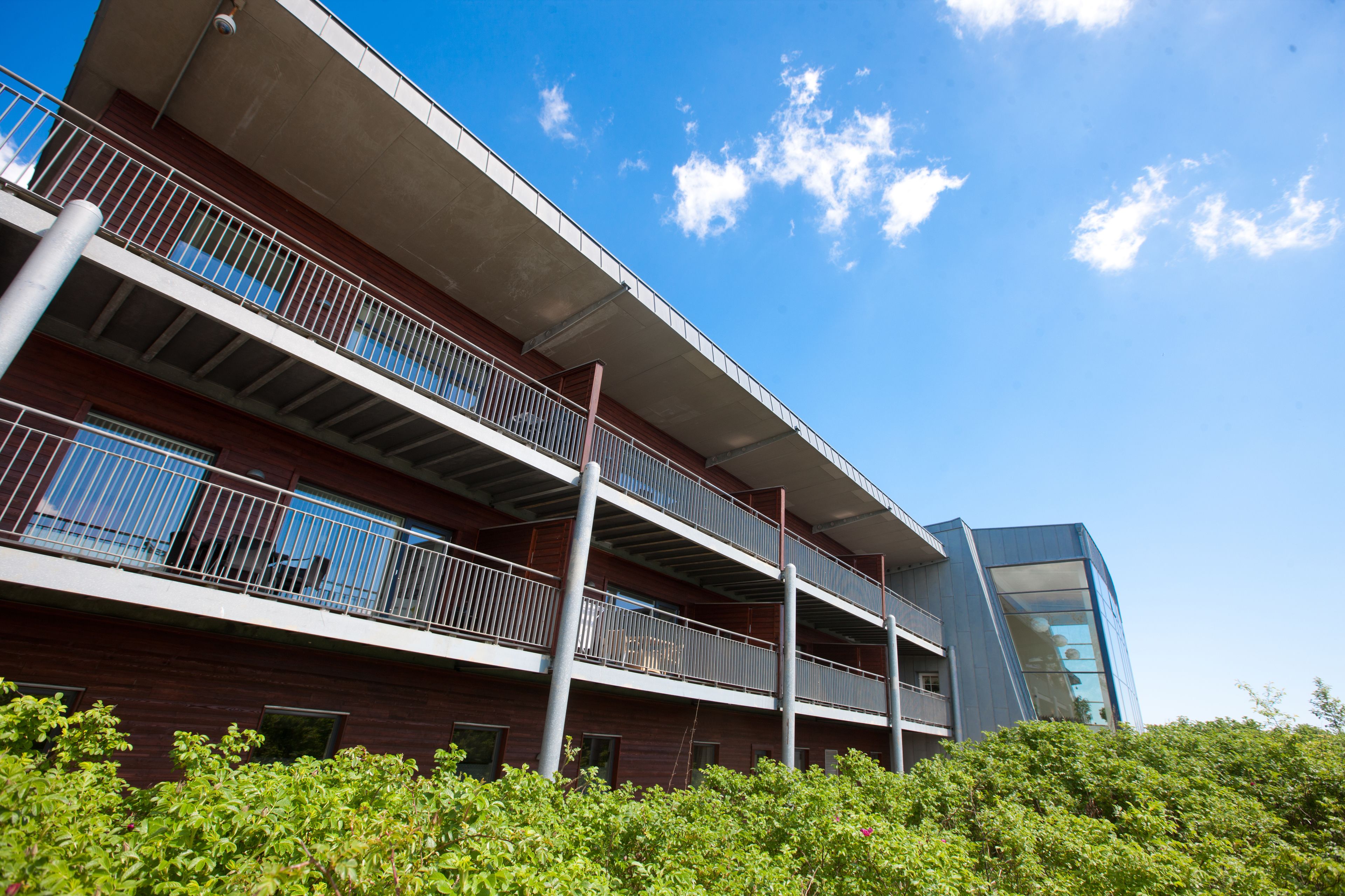 A multi-story building with balconies, large windows, and a modern architectural design.
