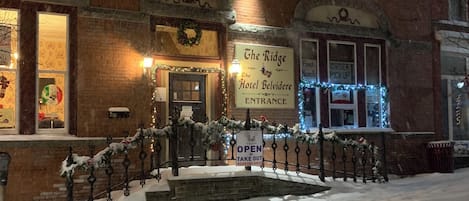 Un edificio de ladrillo con un cartel que dice 'The Ridge Hotel Belvidere Entrance' y un cartel que indica 'Take Out'.