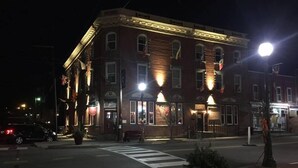 A brick building with multiple windows and a crosswalk in front. - The Hotel Belvidere (Hawley)