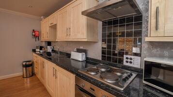 A modern kitchen with wooden cabinets, a stainless steel range, and a tiled backsplash.