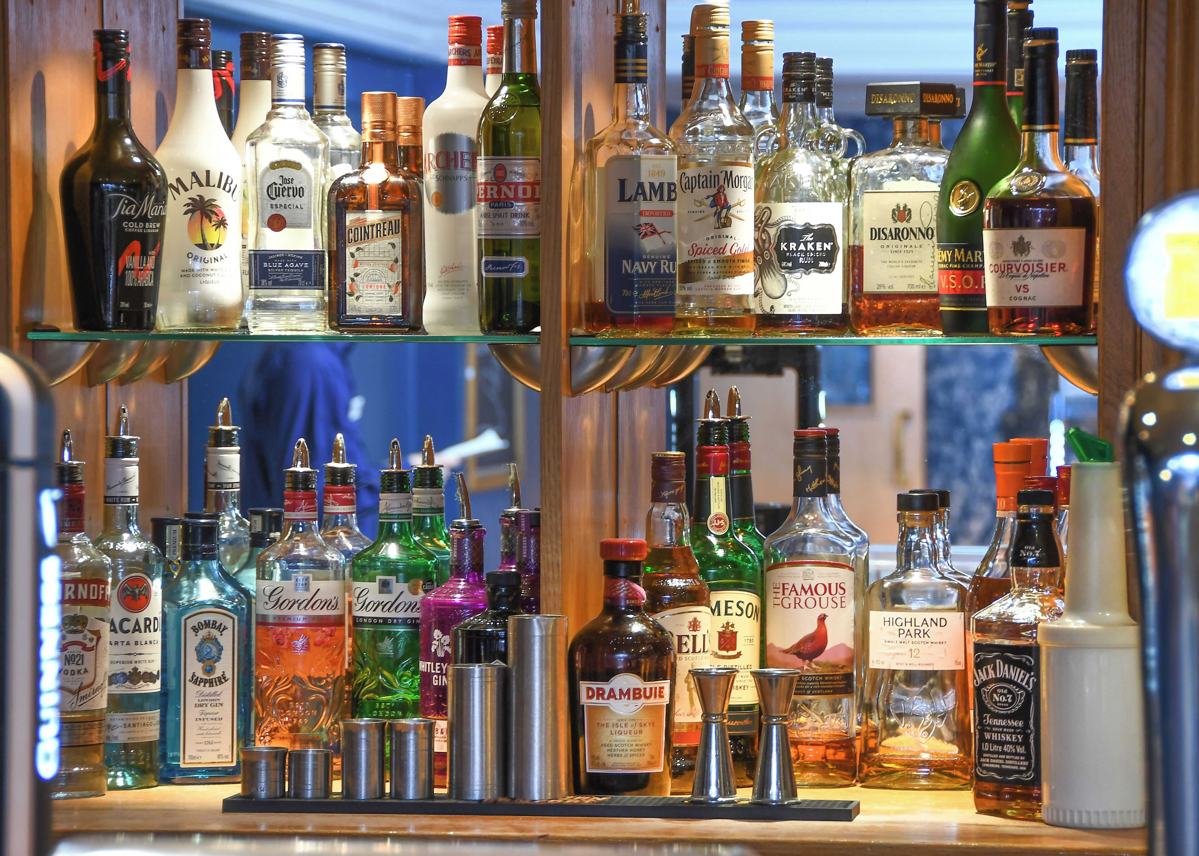 Een bar met verschillende drankflessen en een assortiment glazen.