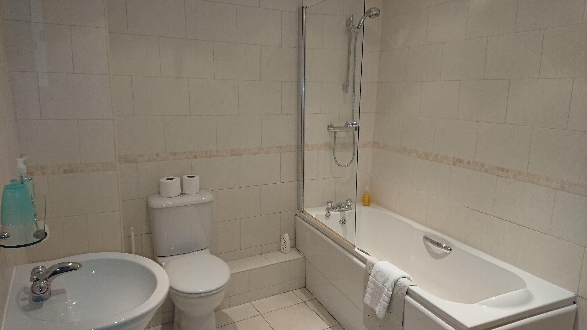 Un baño con inodoro, bidé, lavamanos y bañera.