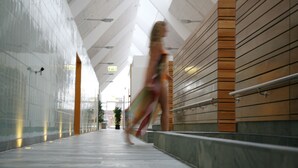 A modern indoor corridor with a high ceiling, a wooden wall on one side, and a glass wall on the other. - Enjoy Resorts Rømø (Rømø)