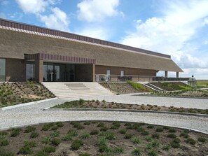 A modern building with a flat roof, large glass windows, and a stepped entrance.
