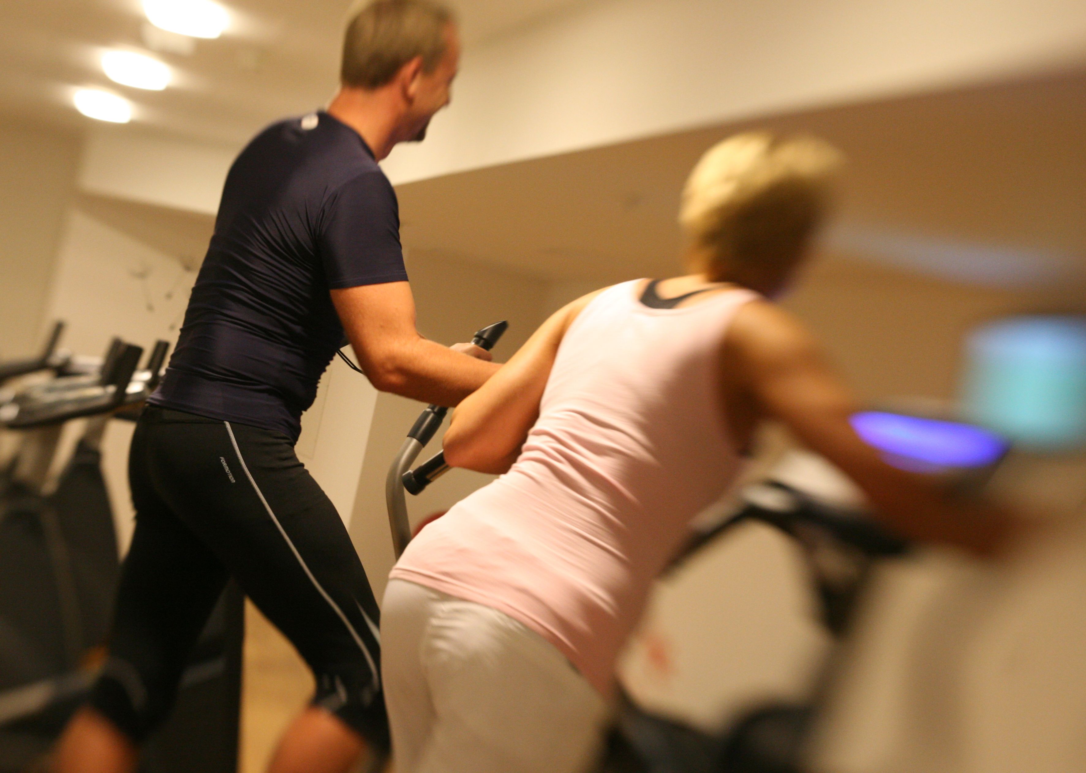 Un gimnasio con bicicletas estáticas y una cinta de correr.