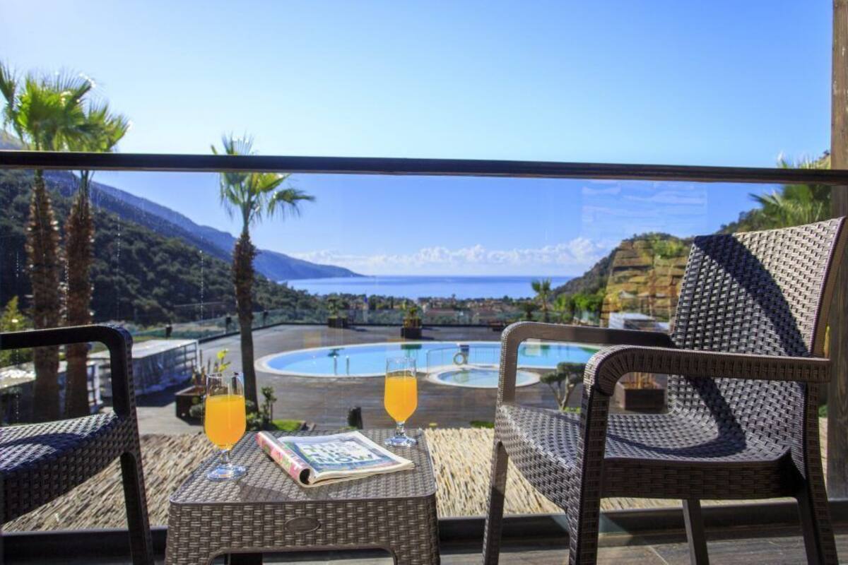 A balcony with wicker furniture, a glass of orange juice, and a menu.