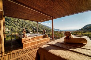 A wooden deck with a hot tub, a towel, and a scenic mountain view. - Manaspark Deluxe Hotel (Fethiye)