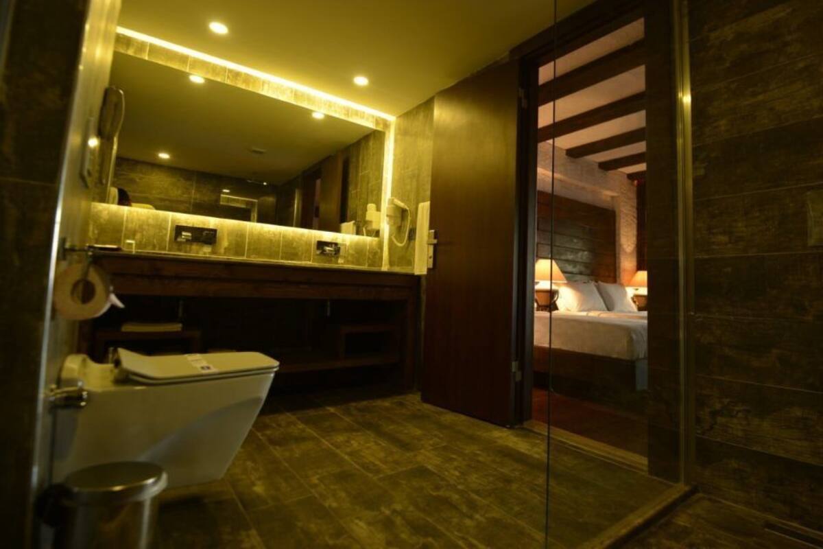 A modern bathroom with a shower, toilet, and a large mirror.
