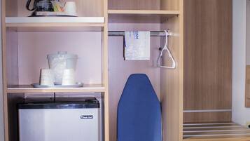 Una kitchenette compacta con refrigerador, cafetera y microondas.