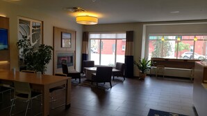A hotel lobby with a reception desk, seating area, and a fireplace. - Microtel by Wyndham Penn Yan Finger Lakes Region (Penn Yan)