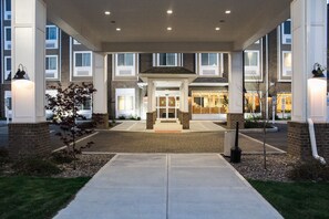 A hotel entrance with a covered walkway, brick pillars, and a central entrance with glass doors. - Microtel by Wyndham Penn Yan Finger Lakes Region (Penn Yan)