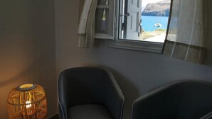 A room with two chairs, a window with curtains, and a wicker lamp. - Avra Pahainas Hotel (Milos)
