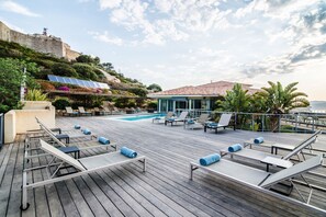 Una piscina al aire libre de temporada, sillones reclinables de piscina