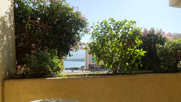 A balcony with a view of the sea, a table, and a chair. - Hotel Mariana (Calvi)