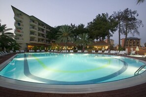 A swimming pool with lounge chairs and palm trees. - Palm Dor Hotel (Manavgat)