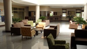 A spacious lobby with multiple seating areas, a reception desk, and large windows allowing natural light. - Palm Dor Hotel (Manavgat)