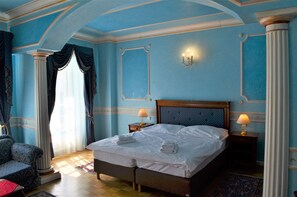 A hotel room with a large bed, two bedside tables with lamps, a chair, and a window with curtains. - Renesance Krasna Kralovna (Karlovy Vary)