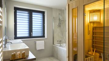 Un baño moderno con un lavamanos grande, una ducha con cerramiento de vidrio y un mueble de tocador de madera.