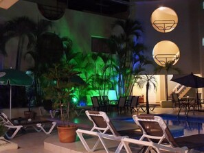 A pool area with lounge chairs, umbrellas, and potted plants. - Hotel Don Andres (Sosúa)