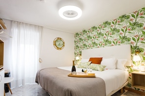 A neatly arranged bedroom with a bed, bedside table, and a wall-mounted lamp. - Pensión Úbeda (Fuenmayor)