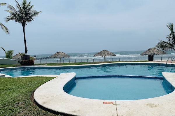 Alberca al aire libre, sombrillas en la alberca y camastros