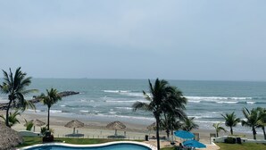 Zona de piscina con vista a la playa y al océano.