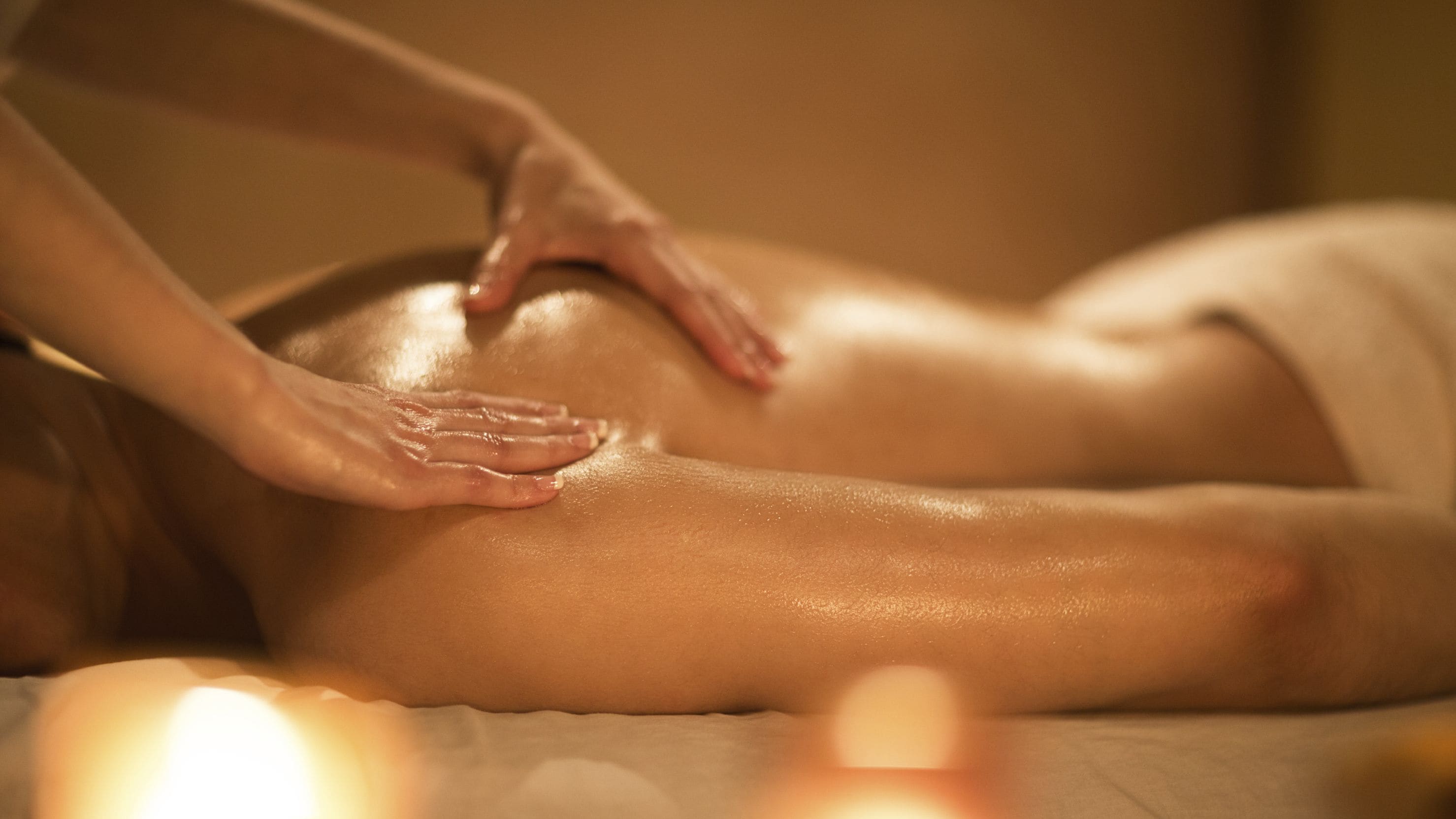 A person receiving a massage on a bed.