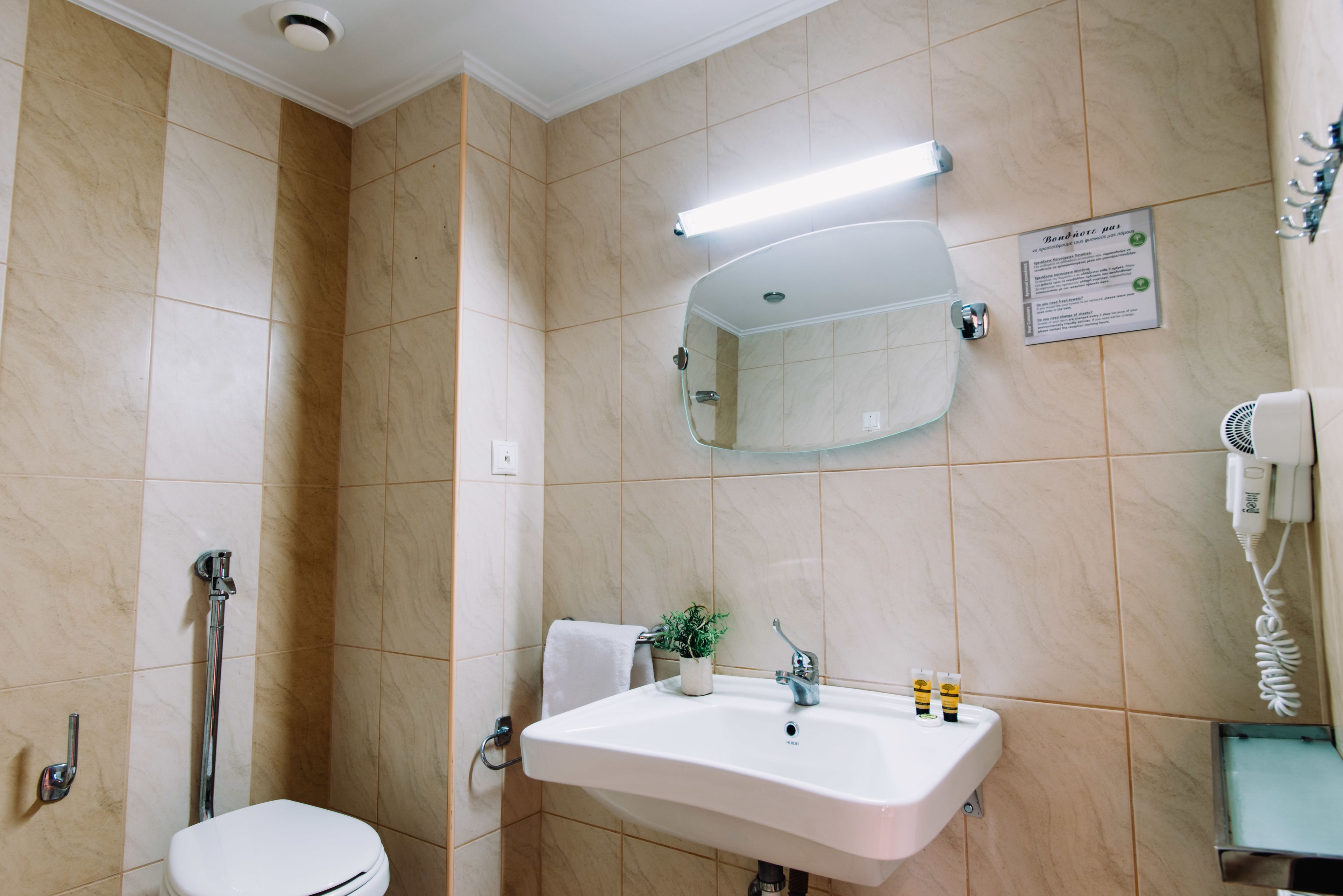 A bathroom with a toilet, sink, and shower.