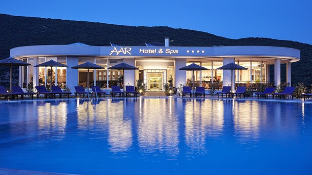 Un hôtel moderne doté d’une piscine, d’un espace extérieur aménagé et offrant une vue sur les montagnes.