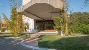 A modern building with a curved roof and a glass entrance. - C Suites (Nîmes)