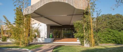 A modern building with a curved roof and a glass entrance.