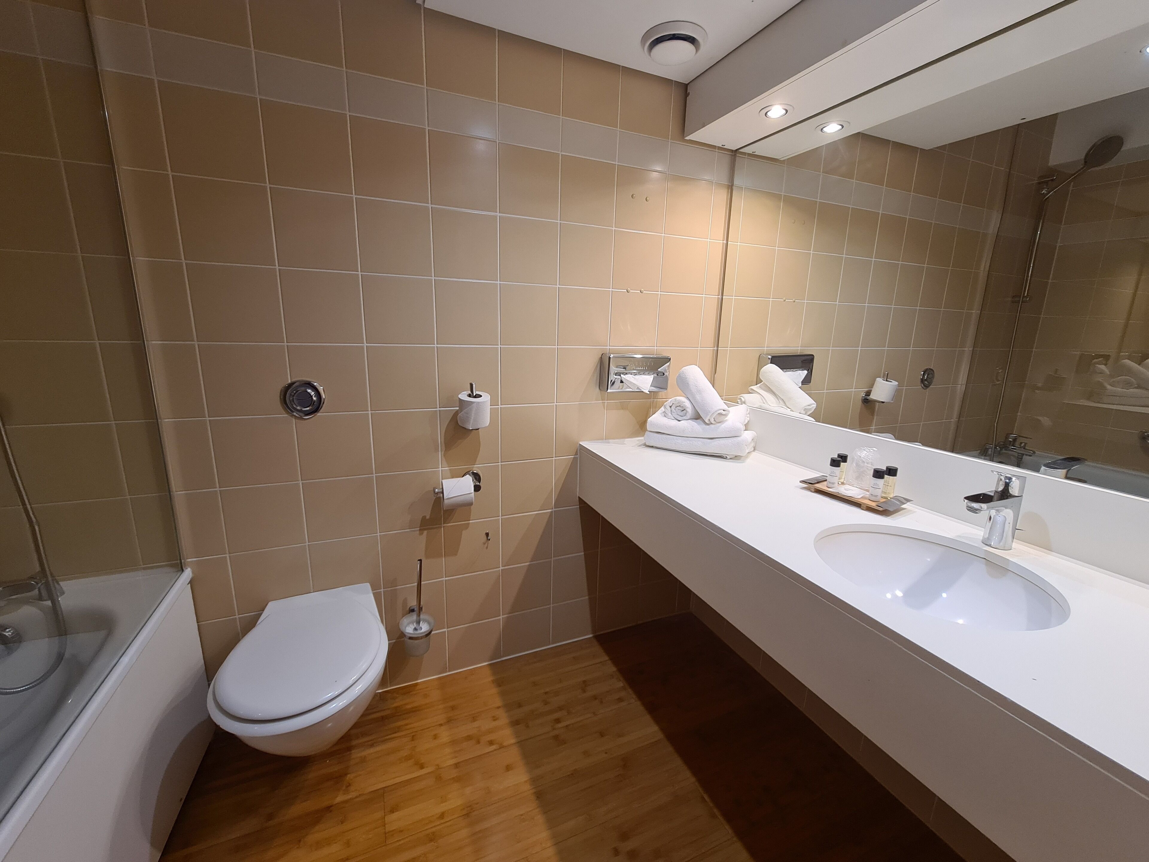A modern bathroom with a toilet, sink, and shower.