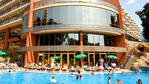Ein großer Innenpool mit mehreren Balkonebenen und Sonnenschutz.