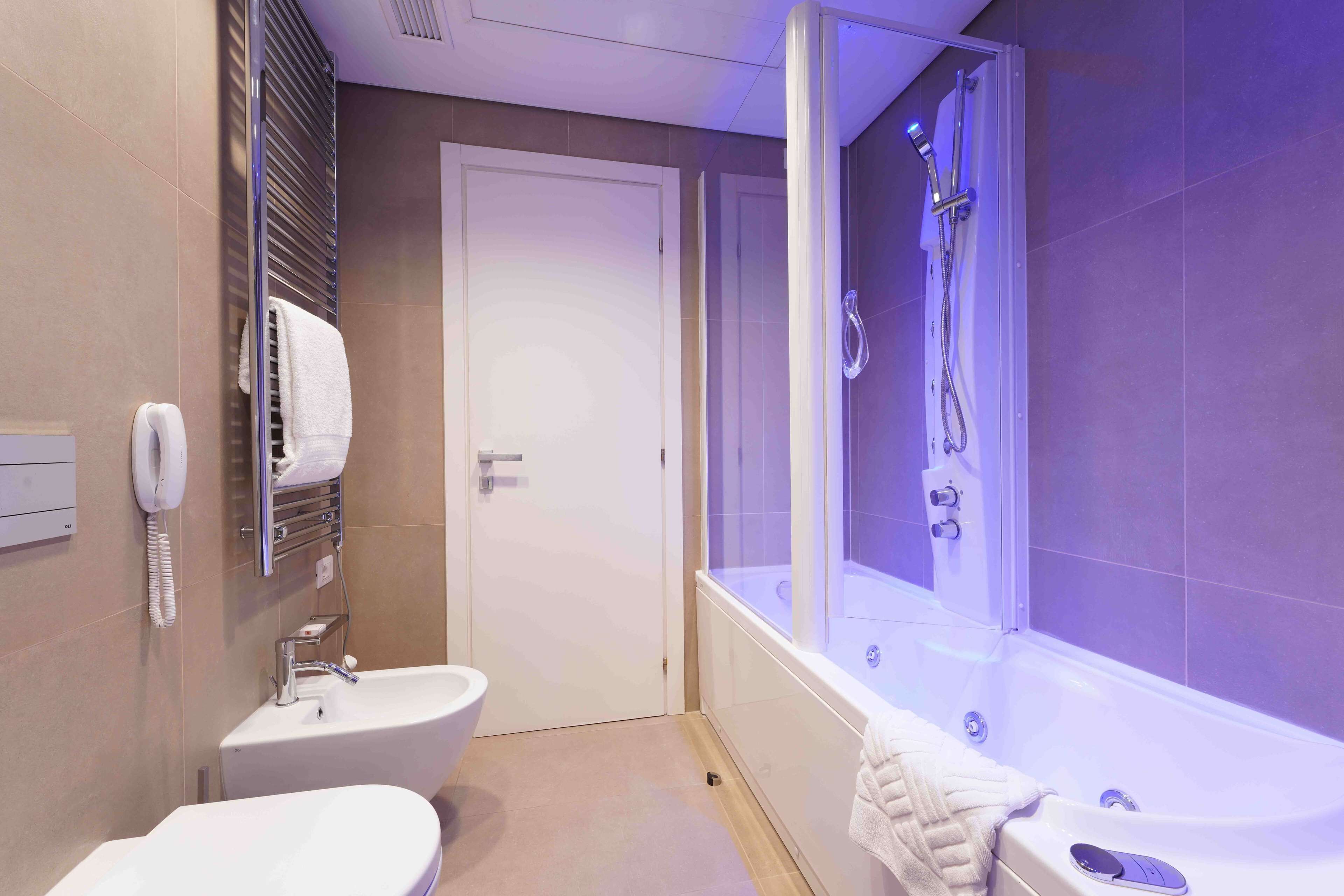 Un baño moderno con una bañera, un lavamanos y un inodoro.