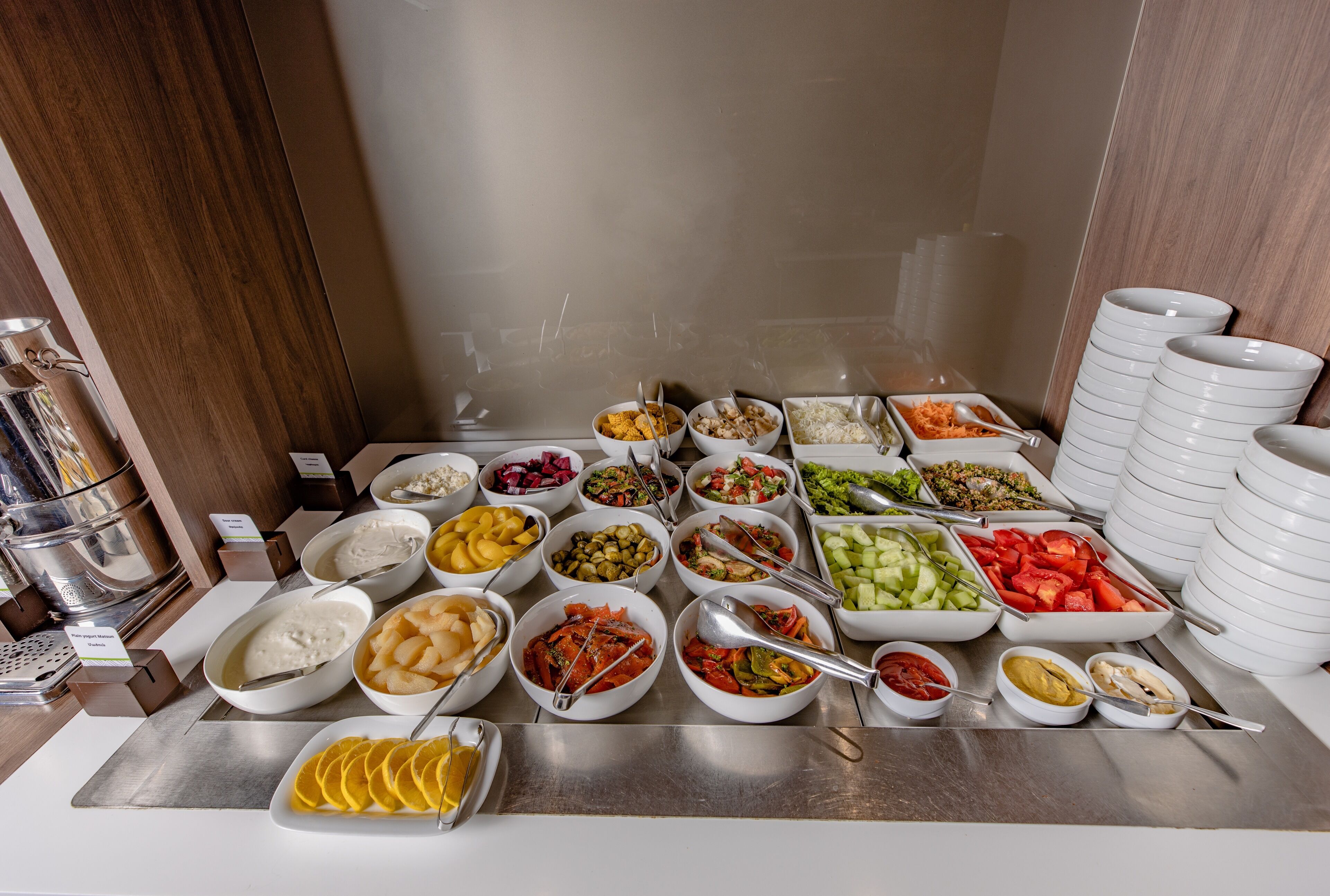 A buffet with various food items and utensils.