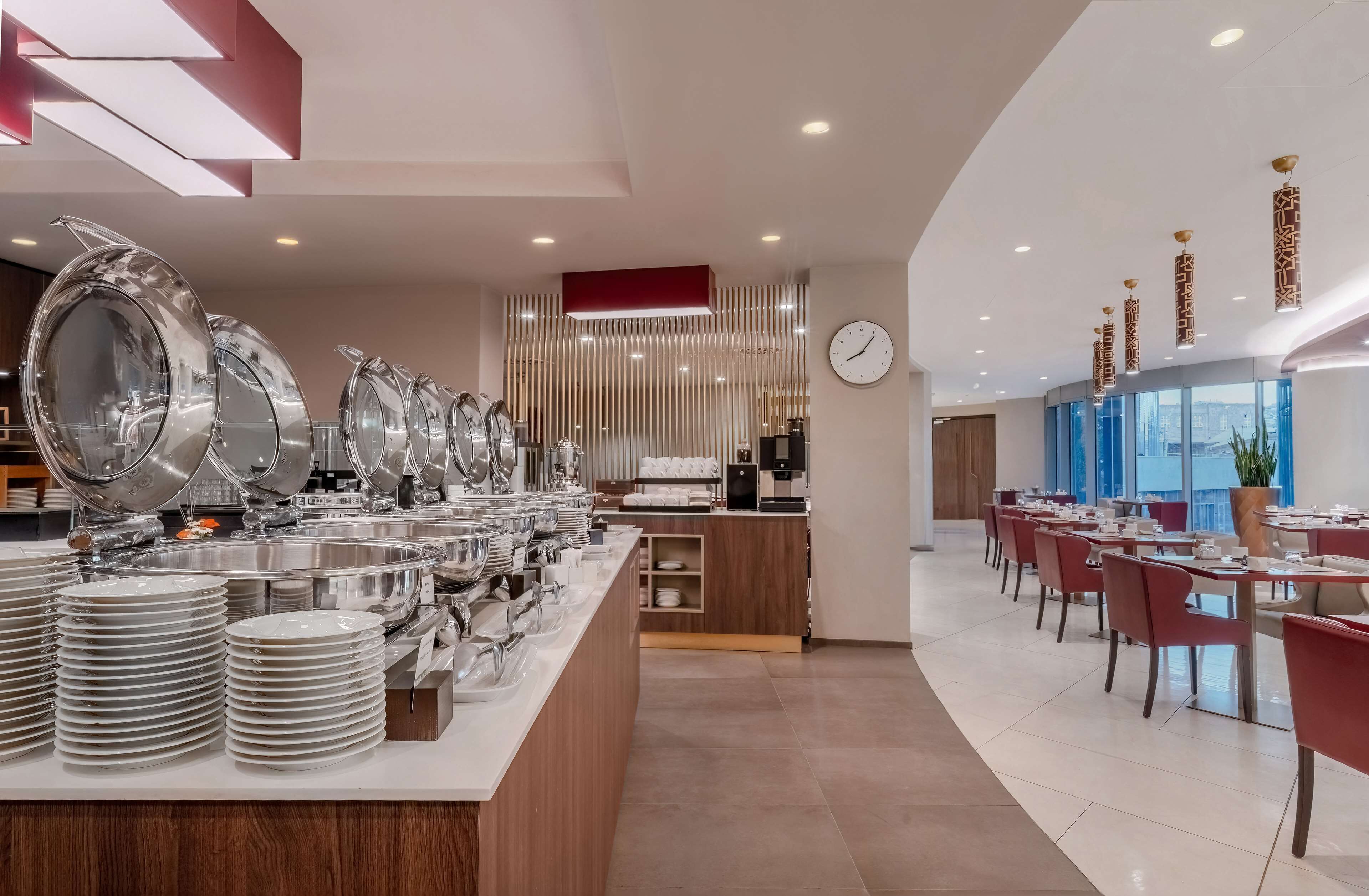 A modern dining area with a buffet setup, including stacked plates and serving dishes.