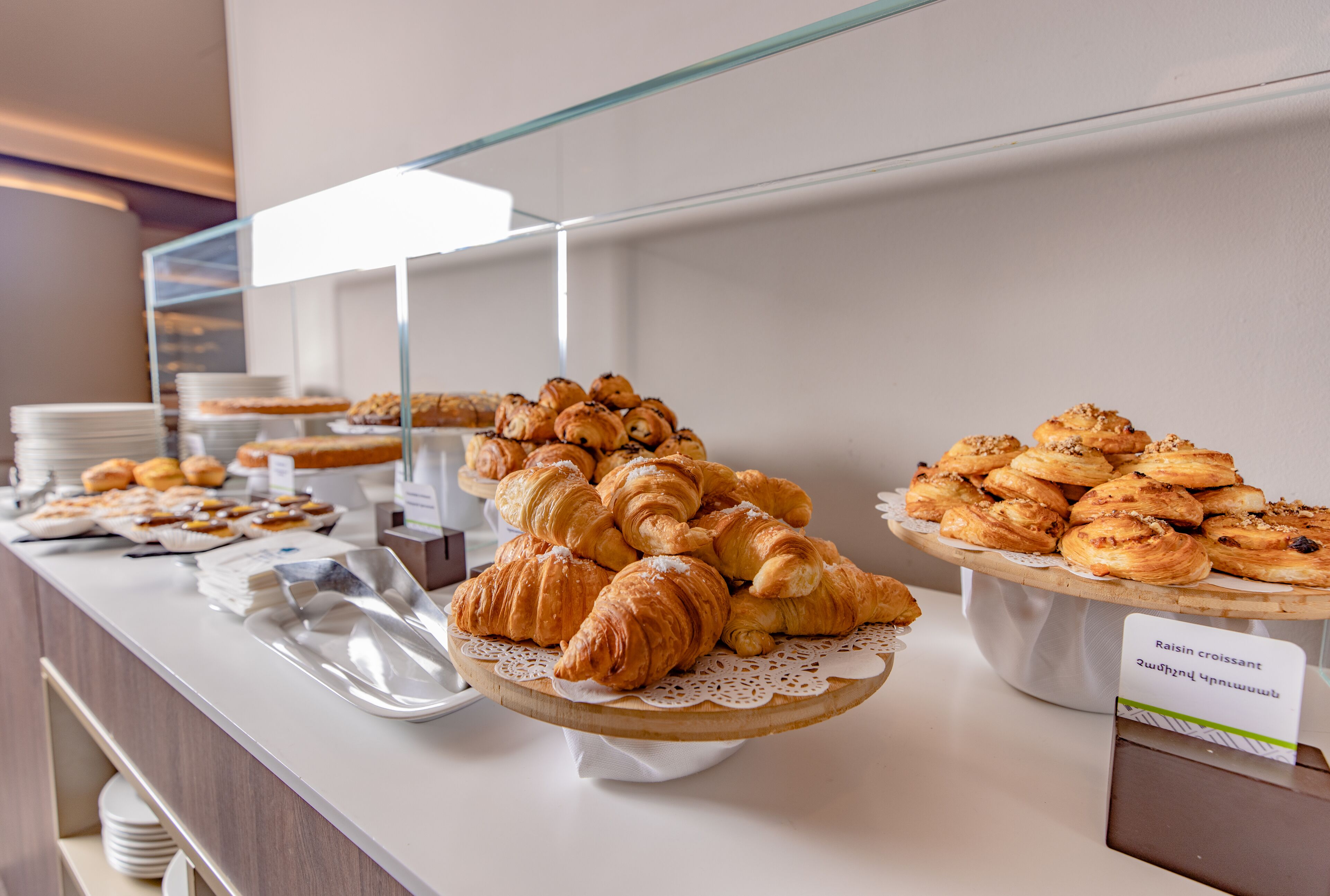 A buffet with various pastries and bread displayed on a counter.
