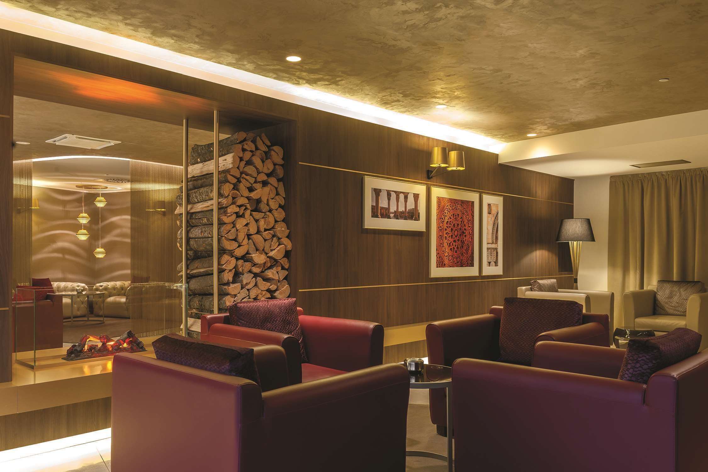A modern lounge area with leather seating, a fireplace, and framed artwork on the walls.